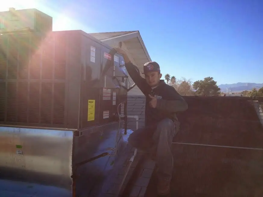 HVAC technician performing Heat Pump Repair on a rooftop unit in Riverview